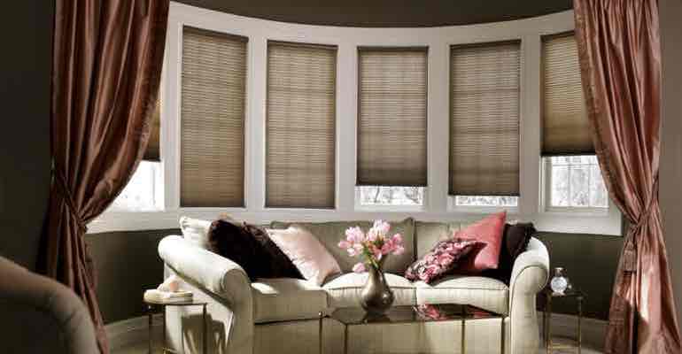 Adjustable honeycomb shades in lounge bow window.